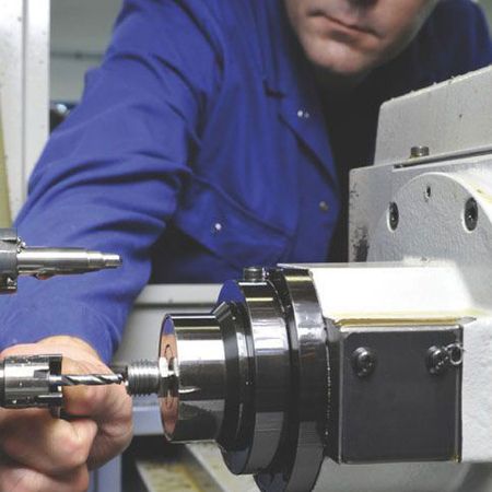 Ein Mitarbeiter bedient eine Drehmaschine